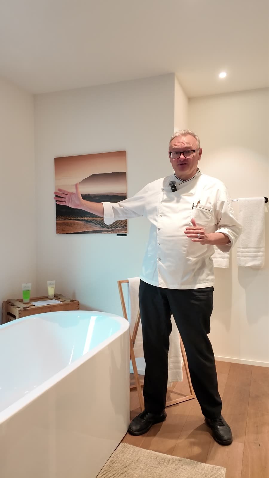 Albi von Felten zeigt im Bad der Suite auf die freistehende Badewanne.